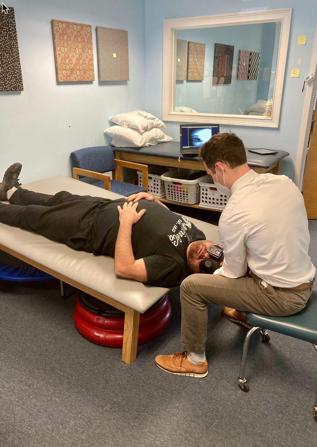 Testing a patient with BPPV on a large, low table tilted up to accommodate a patient with neck and back pain, using wireless Synapses infrared video goggles